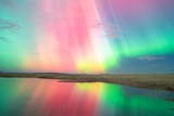 A multicoloured aurora over a lake. 