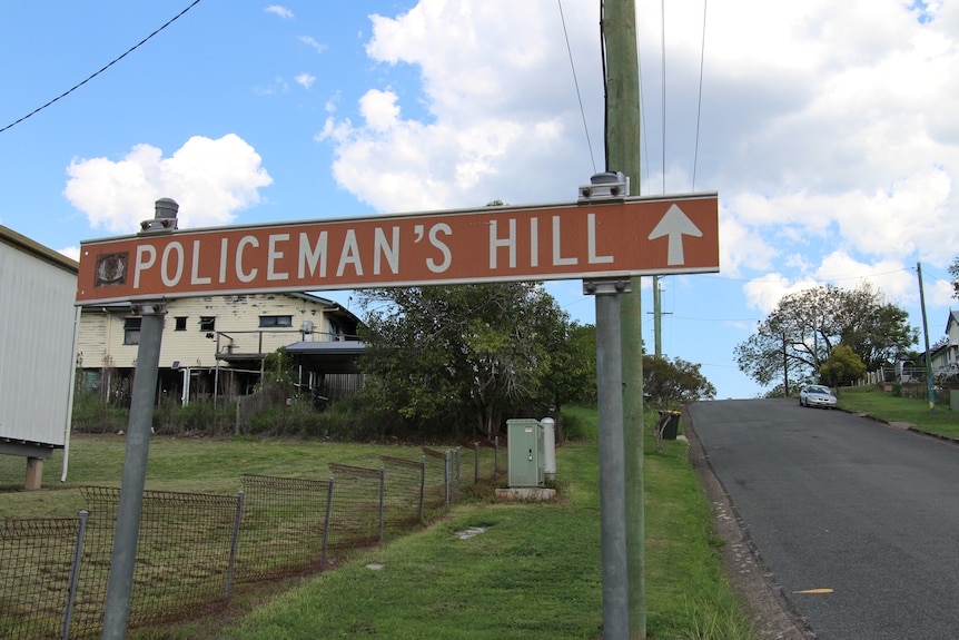 A street sign reading 'Policeman's Hill' pointing up a steep slope