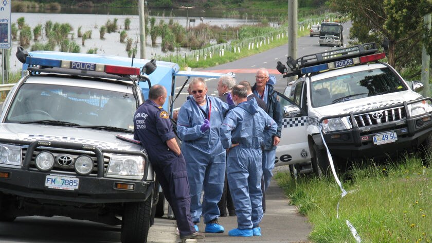 Tasmanian police officers in forensics suits outside Austins Ferry house.
