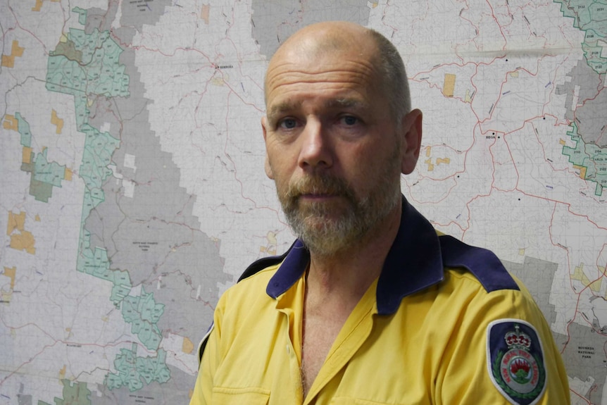 A man stands in RFS uniform in front of a map