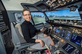 Natasha Heap smiles while sitting in the cockpit of a plane.