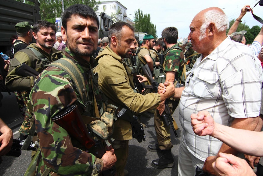 Pro-Russian separatists speak with local residents during a rally in Donetsk on May 25.
