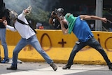 Demonstrators throw stones during a protest in Venezuela