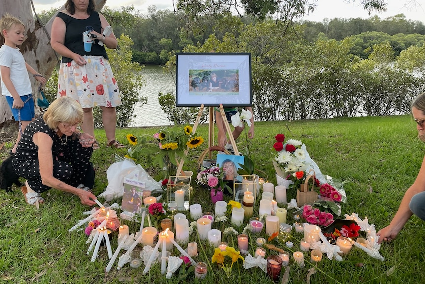 A makeshift shrine dedicated to Wendy Sleeman with flowers, candles and a photo.