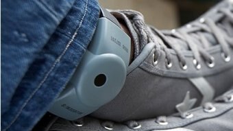 A GPS tracker on the ankle of somebody wearing jeans