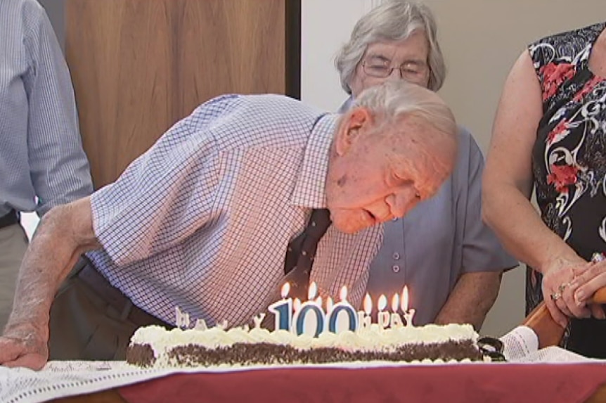 Chuck Younger blows out the candles on his birthday cake.