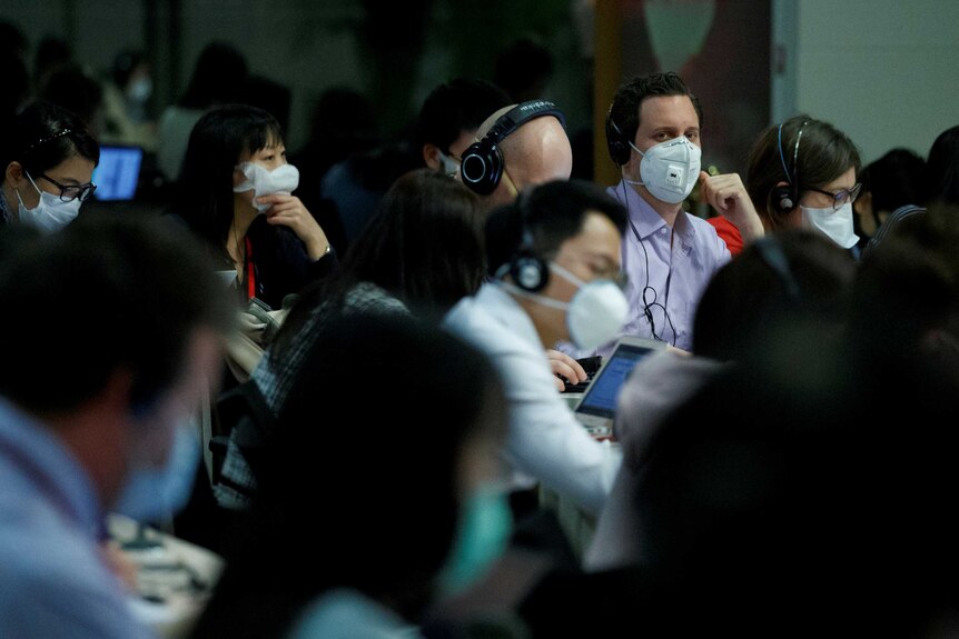 A group of journalists wearing face masks at a press conference