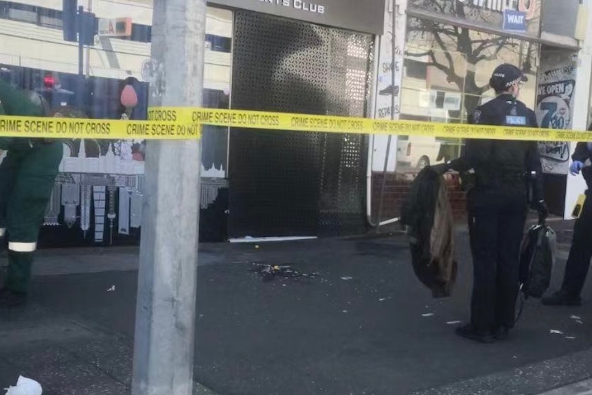 Police and crime scene tape outside a city building