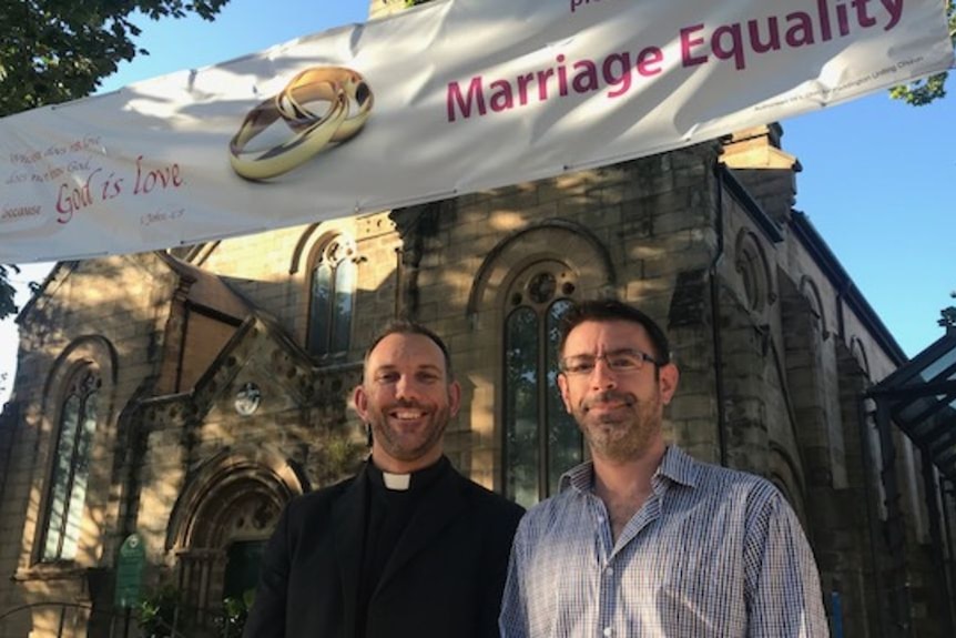 Reverend Ben Gilmour and his partner Scott Miner standing in front of the Paddington Uniting Church.