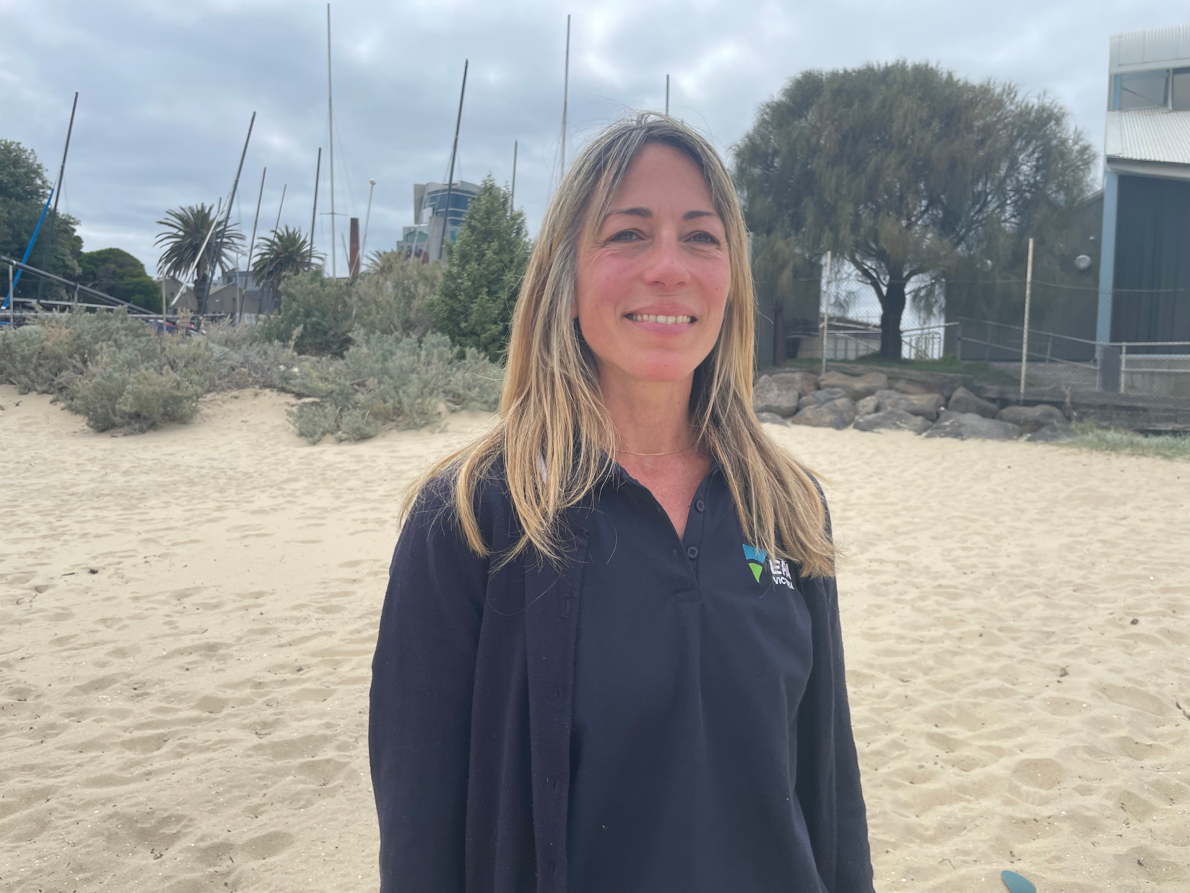 Una mujer está parada en la playa sonriendo