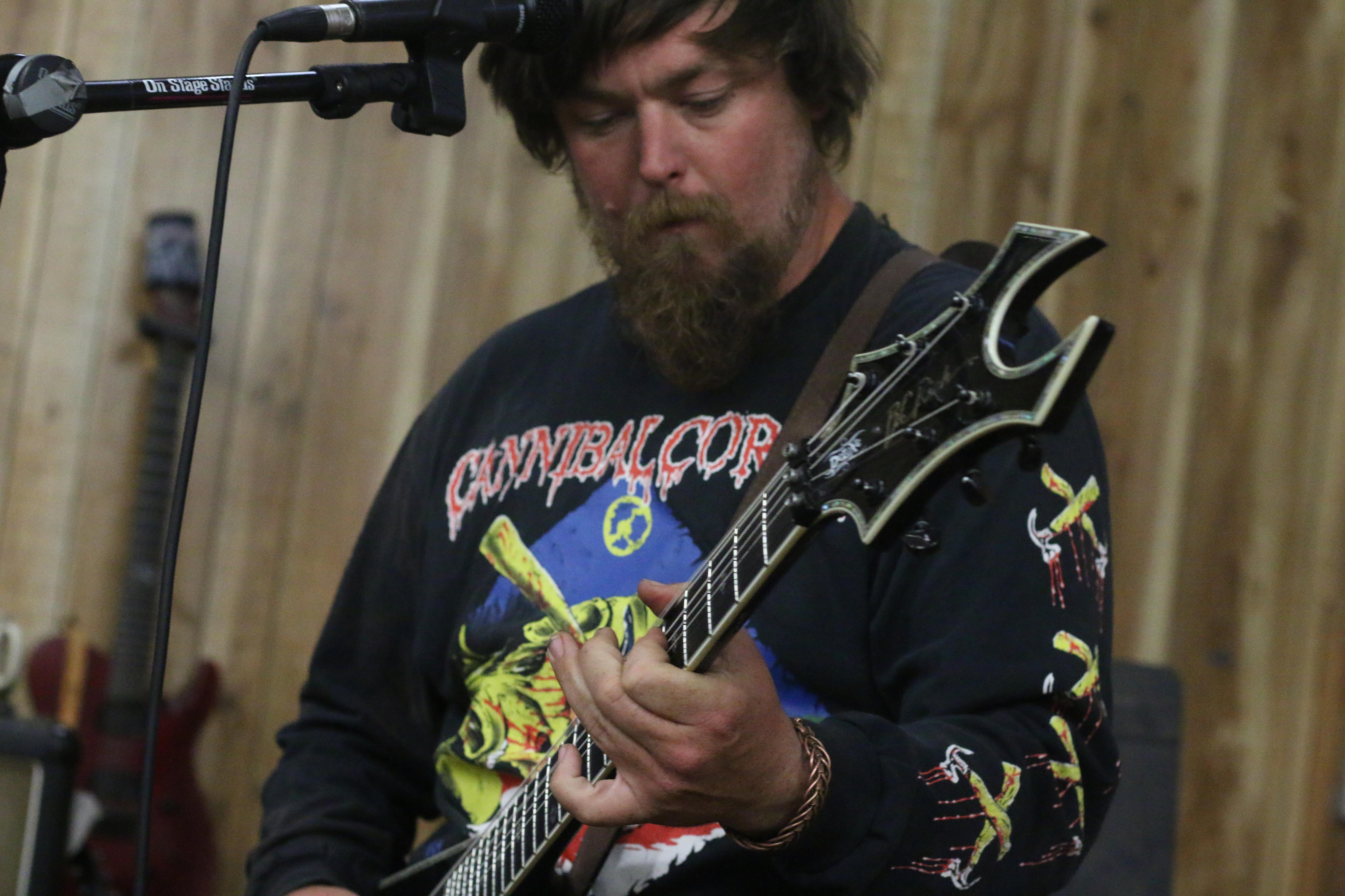 Um homem toca guitarra em uma banda de heavy metal.
