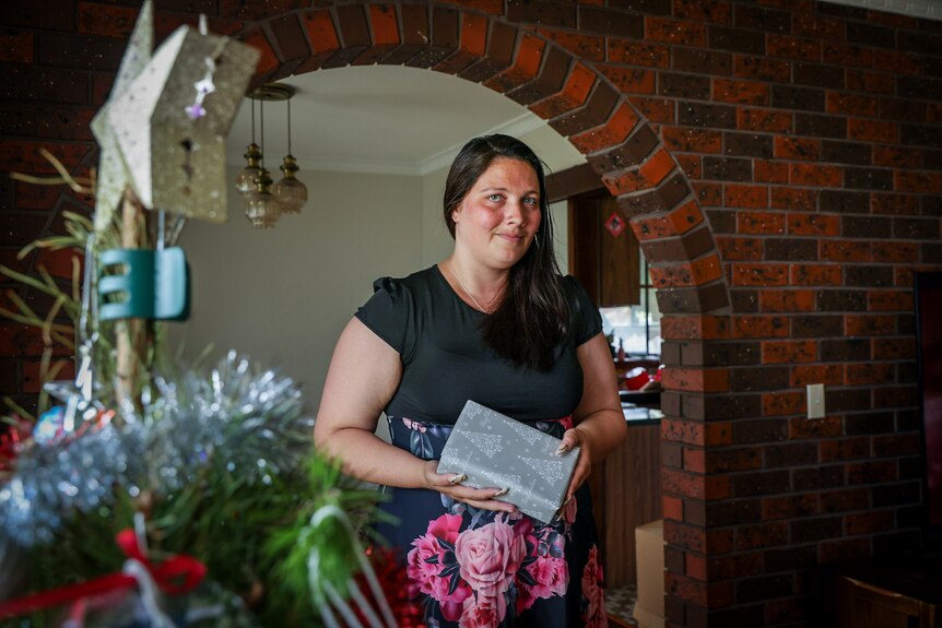 Kate Nichols holds a wrapped Christmas gift at her home in outer suburban Melbourne