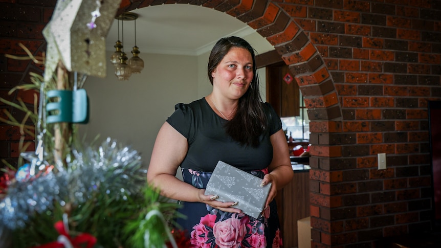 Kate Nicol holds a wrapped Christmas gift at her home in outer suburban Melbourne