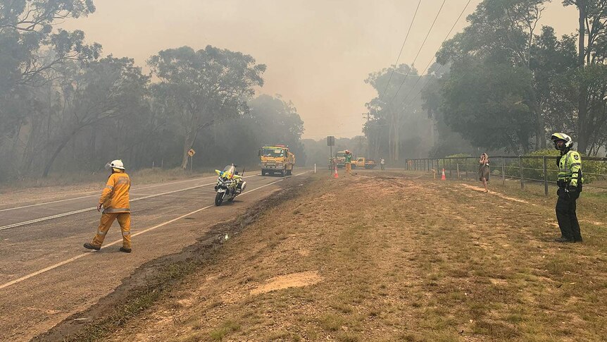 Emergency authorities on a road at the scene of a bushfire at Cooroibah.