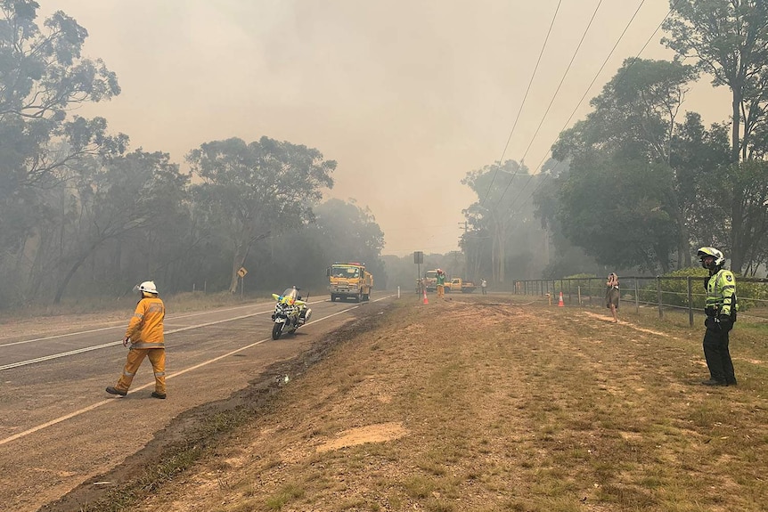 Emergency authorities on a road at the scene of a bushfire at Cooroibah.