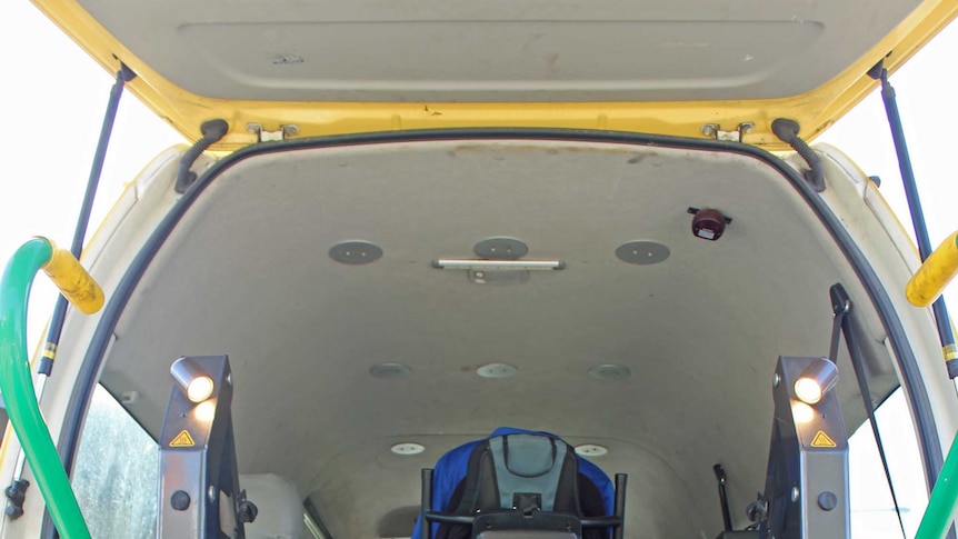 A man in a wheel chair in sitting in a yellow taxi van