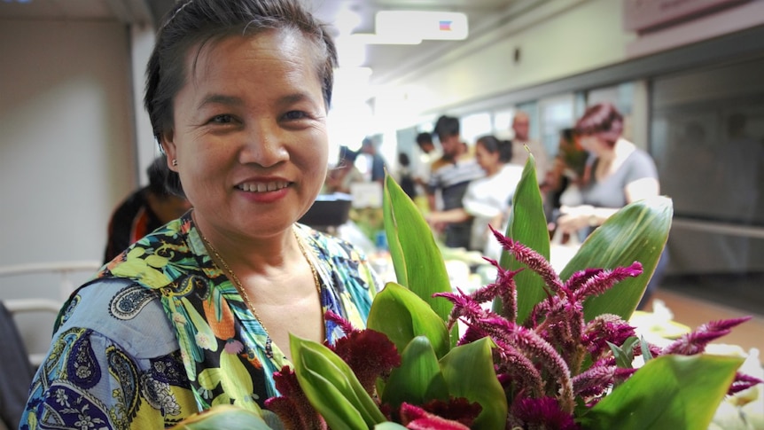 A woman holding a bunch of flowers and smiling