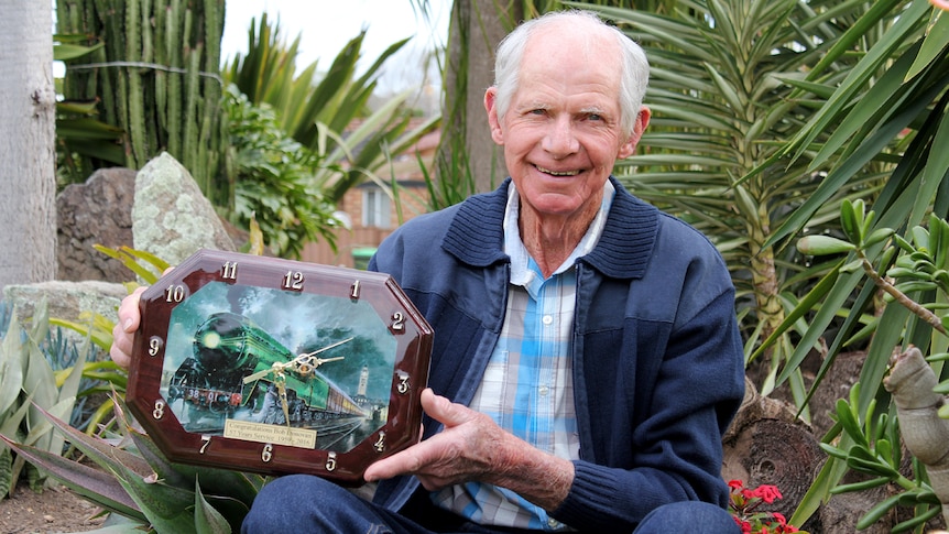 A man holds a lifetime achiever award upon his retirement.