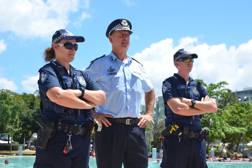 paul taylor stands with two officers on either side of him in cairns.
