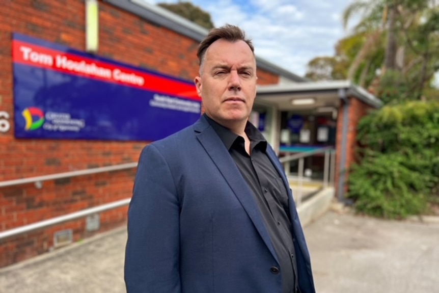 a man in a suit looking at the camera. He looks very serious.