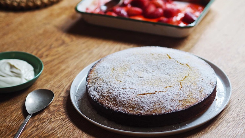 Lemon almond cake dusted with icing sugar served with yoghurt and roasted strawberries, an easy cake for afternoon tea.