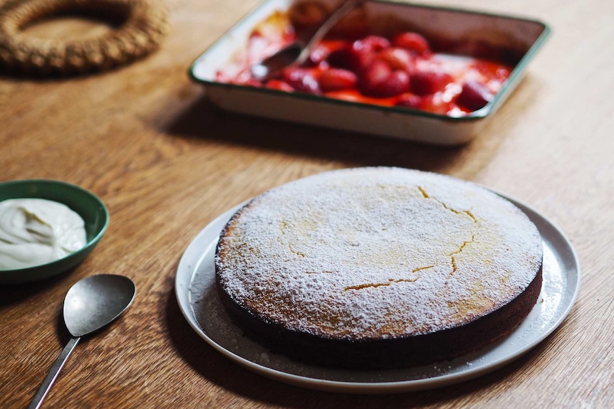 Lemon almond cake dusted with icing sugar served with yoghurt and roasted strawberries, an easy cake for afternoon tea.