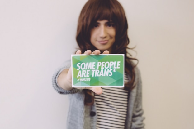 Margot Fink from Minus18 holds a sign that reads, 'Some people are trans'.