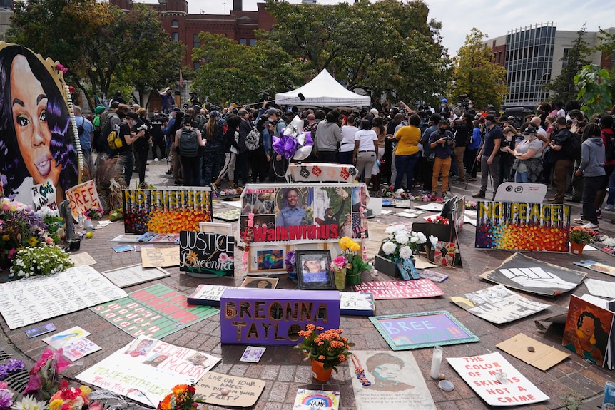 People gather in Jefferson Square among tributes to Ms Taylor awaiting word on charges against police officers.