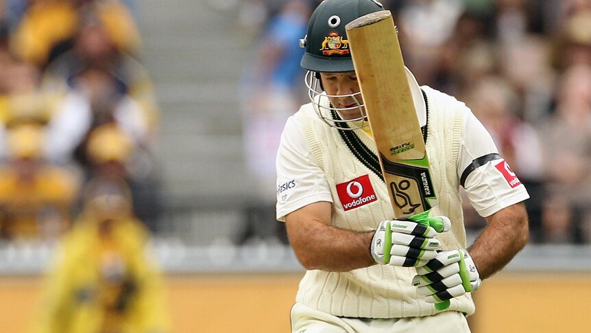 Ricky Ponting kicks the ball away from the stumps after being struck in the helmet.