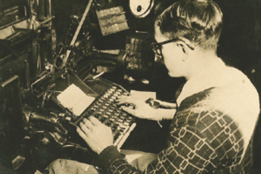 An old black and white photo of Norm Marston typing at a typewriter.