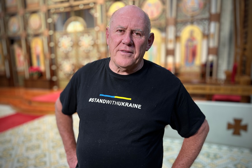 A man wearing a t shirt with the slogan I stand with Ukraine