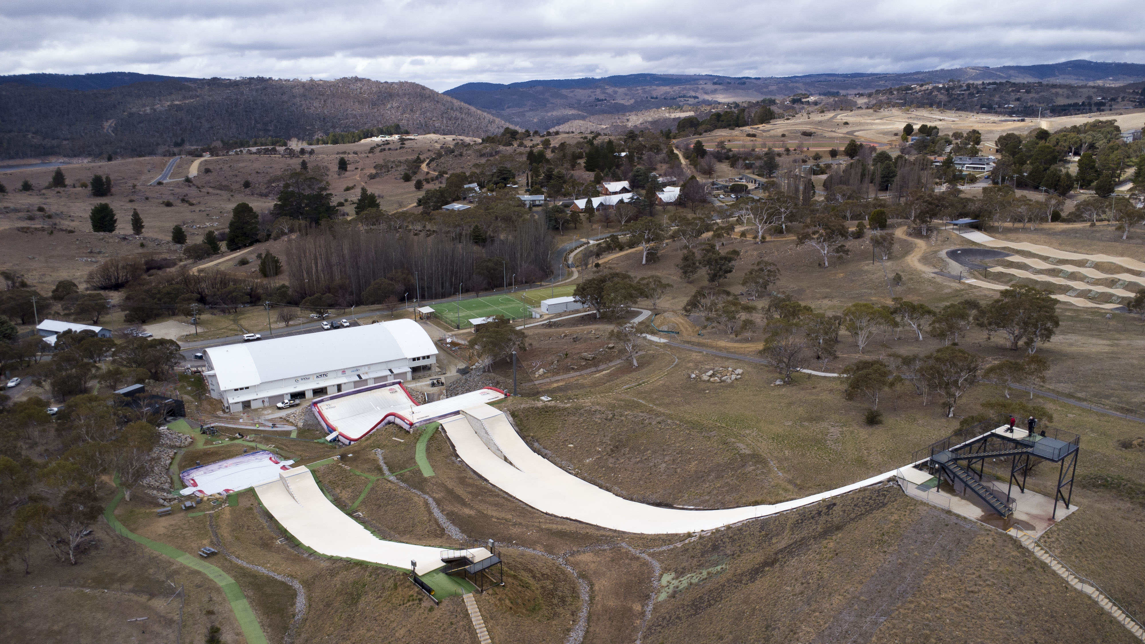 Una toma de drones de una bolsa de aire salta sobre una colina cubierta de hierba.