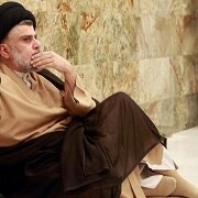 Sadr is seen sitting on the floor.