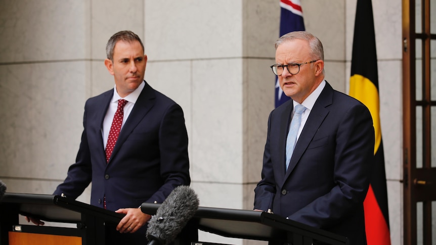 Jim Chalmers stands behind a podium on the left and Anthony Albanese behind one on the right in a courtyard