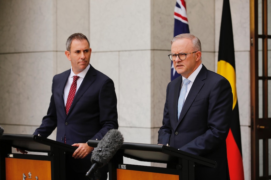 Jim Chalmers stands behind a podium on the left and Anthony Albanese behind one on the right in a courtyard