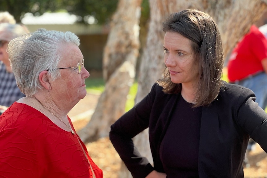 NSW Housing Minister Rose Jackson speaking to a woman in a red dress in Coffs harbour 