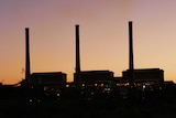 A coal-fired power station in silhouette.