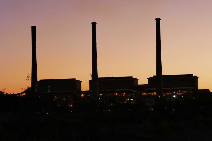 A coal-fired power station in silhouette.