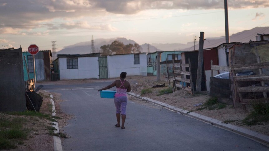 Township resident walking down the street with a washing basin