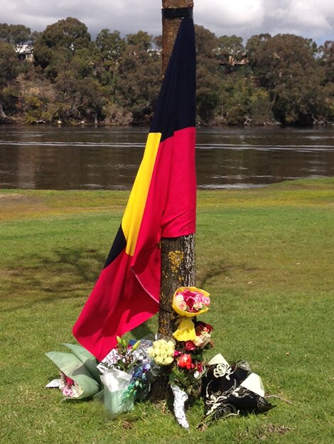 An Aboriginal flag with flowers around it.