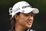 An Australian female golfer holds a golf ball in her right hand at the Australian Open.