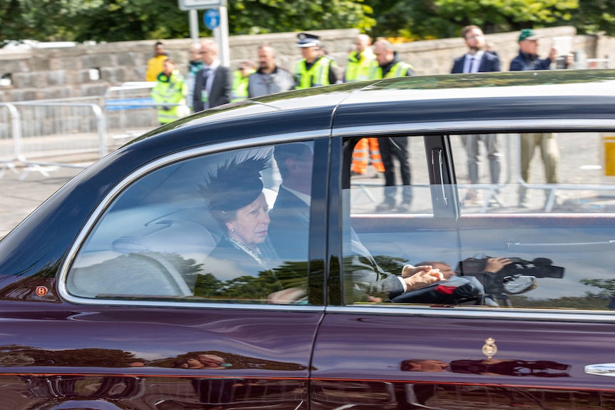 Princess Anne sits in the back of a car.