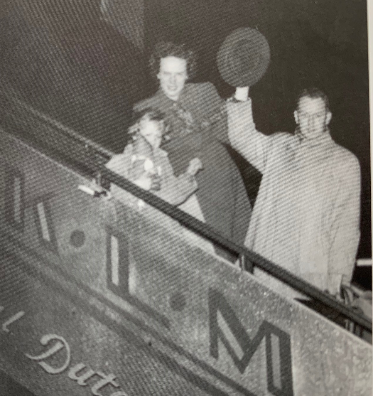 Black and white photo of two adults and a child walking onto a plane.