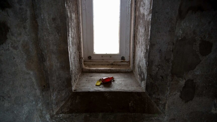 A set of keys rests on the sill of a window inside the Gabo Island lighthouse, the walls a mottled texture.