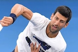 Novak Djokovic hits a serve during practice