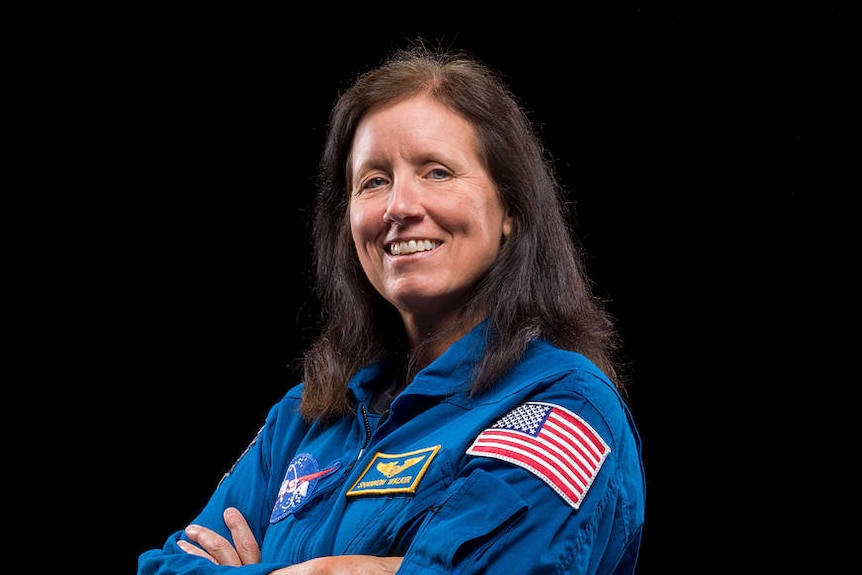 A woman wearing blue coveralls