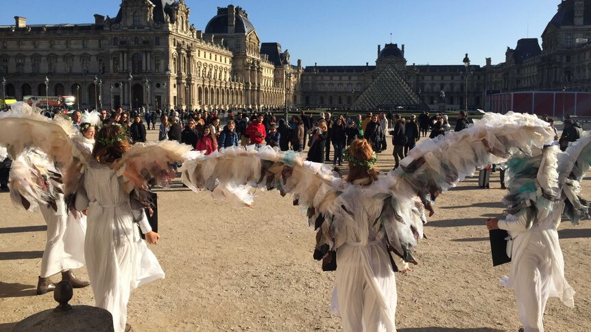 Australian climate change activists dressed as angels protest outside the Louvre during Paris climate talks.