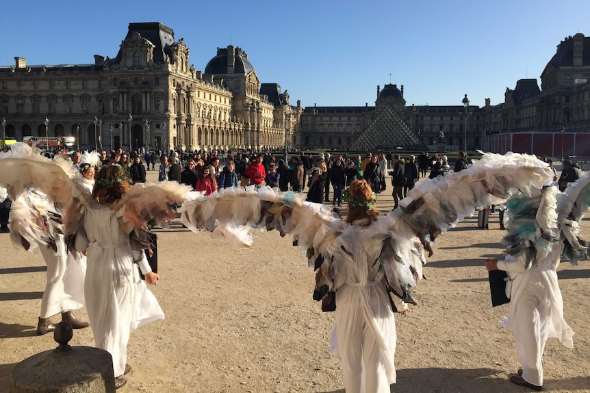 Australian climate change activists dressed as angels protest outside the Louvre during Paris climate talks.