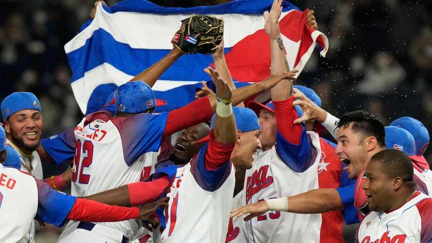 Cuban players celebrate with their flag after beating Australia in the World Baseball Classic.