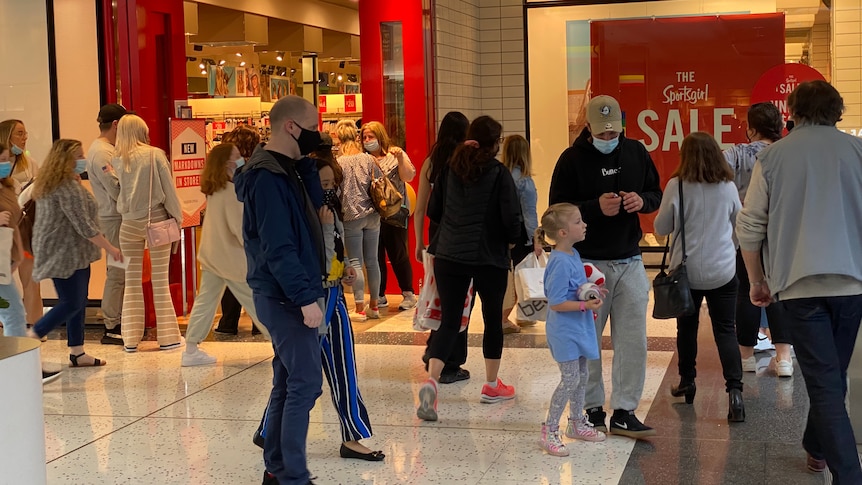 Shoppers outside a store in a shopping mall